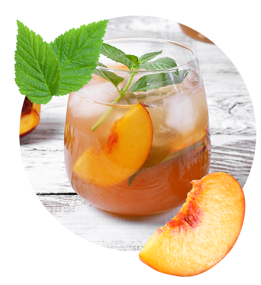 A refreshing glass of iced tea garnished with slices of juicy peaches and fresh mint leaves