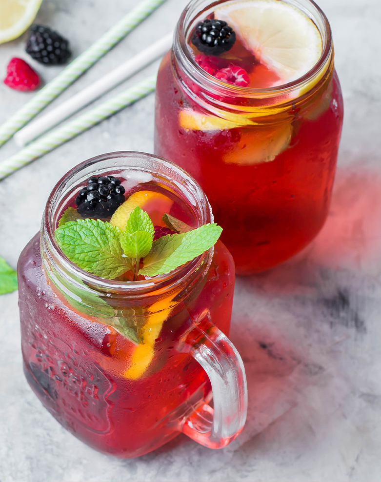 Two mason jars filled with a refreshing mix of fruit and ice