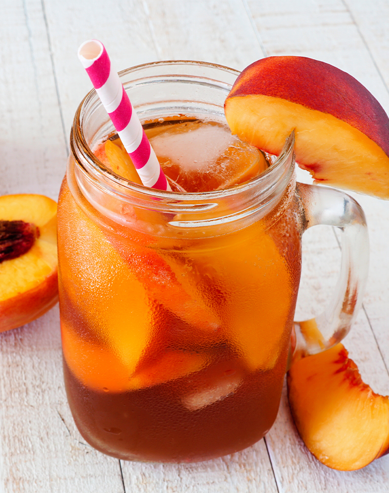 A mason jar filled with liquid and sliced peaches