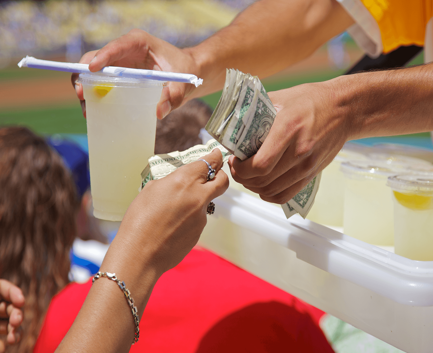 a person exchanging money with another person at a baseball game