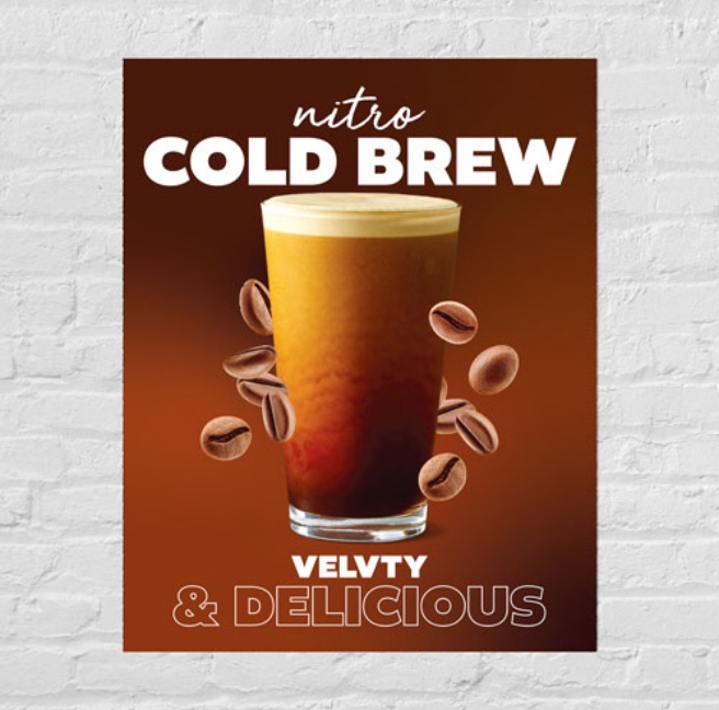 a poster on a brick wall advertising a cold beverage